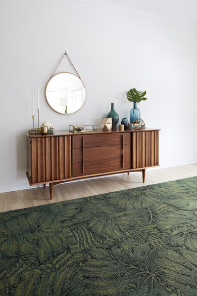 Wooden credenza with FLOR Palm Reader area rug shown in Kale