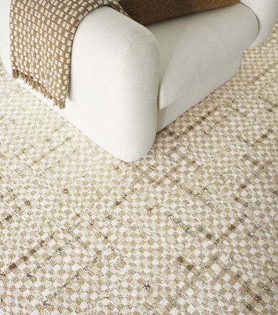 Detail of FLOR Check It Out area rug with white contemporary armchair and blanket