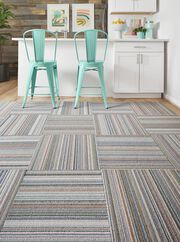  Kitchenette bar seating area with pastel blue chairs and FLOR area rug Thick And Thin shown in Wave