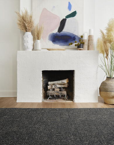 FLOR Hemline living room rug in Flint in front of a white fireplace.