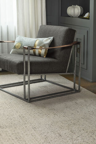 FLOR Beck And Call area rug in Pearl under a gray chair. 