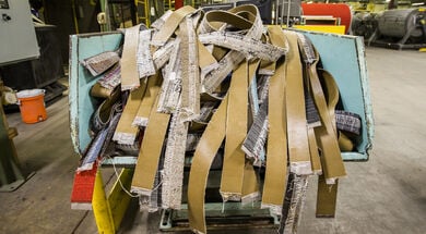 FLOR carpet tiles being recycled in a light blue machine.