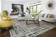 Better Half living room area rug in Fog, shown with a mint green couch and a wood and glass table.