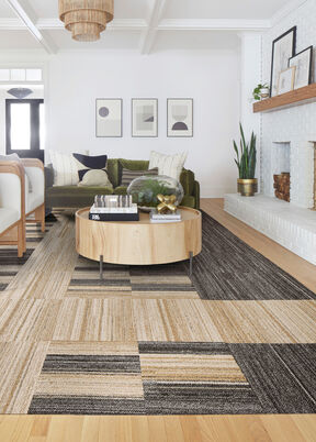 Living room with NEW FLOR Stratosphere area rug shown in Tan with Hemisphere in Tan and Peninsula in Mahogany