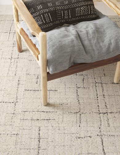 Detail of chair with FLOR Carry a Torch area rug shown in Cream