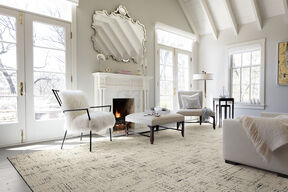 Tuxedo Pocket living room area rug in Pearl, shown with a white marble fireplace and white furniture.
