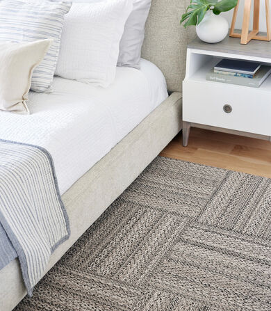 Bedroom detail showing FLOR Skipping Rope area rug in Beige