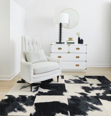 Light neutral corner seating area with FLOR Mod Cow area rug shown in Black