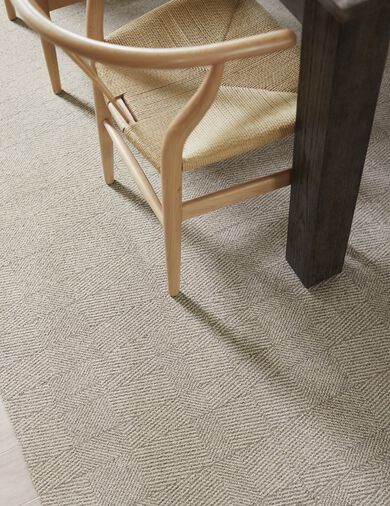 Detail of dining room with FLOR Tweed Indeed area rug shown in Dune