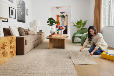Woman installing FLOR tiles in living room