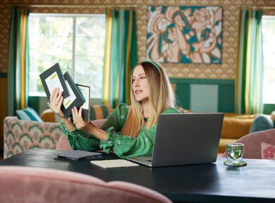 Dani Dazey looking at FLOR carpet tile swatches while using FLOR's Design Studio