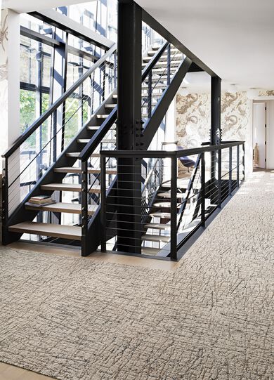 Iron staircase landing with FLOR Turkish Smoke area rug shown in Tan