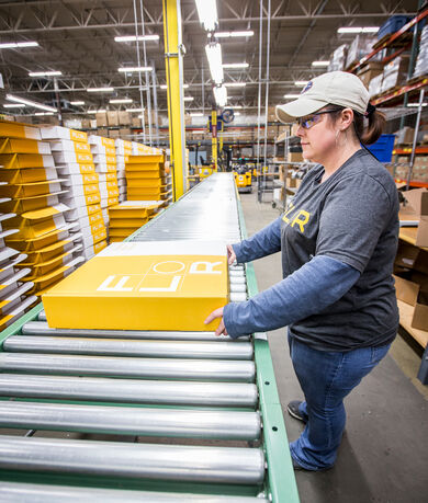 FLOR employee packaging up tiles into shipping box