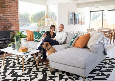 Mid-Century Modern living room with family and dog featuring FLOR area rug Twisted Spokes shown in Black