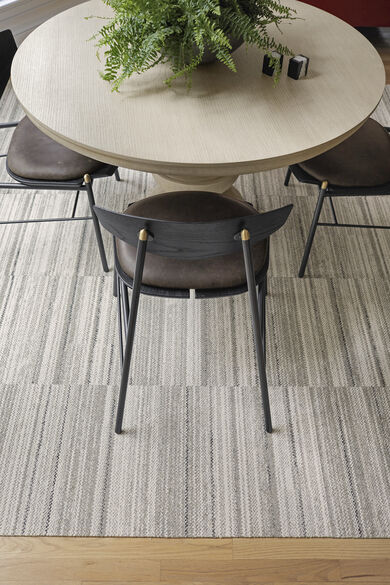 Table and Chair with FLOR Hemisphere area rug shown in Pigeon.