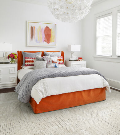 FLOR On The Dot bedroom rug in Bone / Silver with an orange, gray, and white bed.