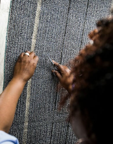 FLOR employee working closely on FLOR area rug material