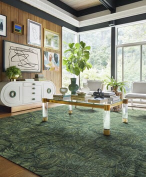 FLOR Palm Reader area rug in Kale with a wood and marble carved coffee table, green trim,and chartreuse accent chair